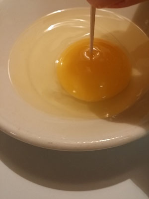 Poke hole in center of egg yolk with toothpick